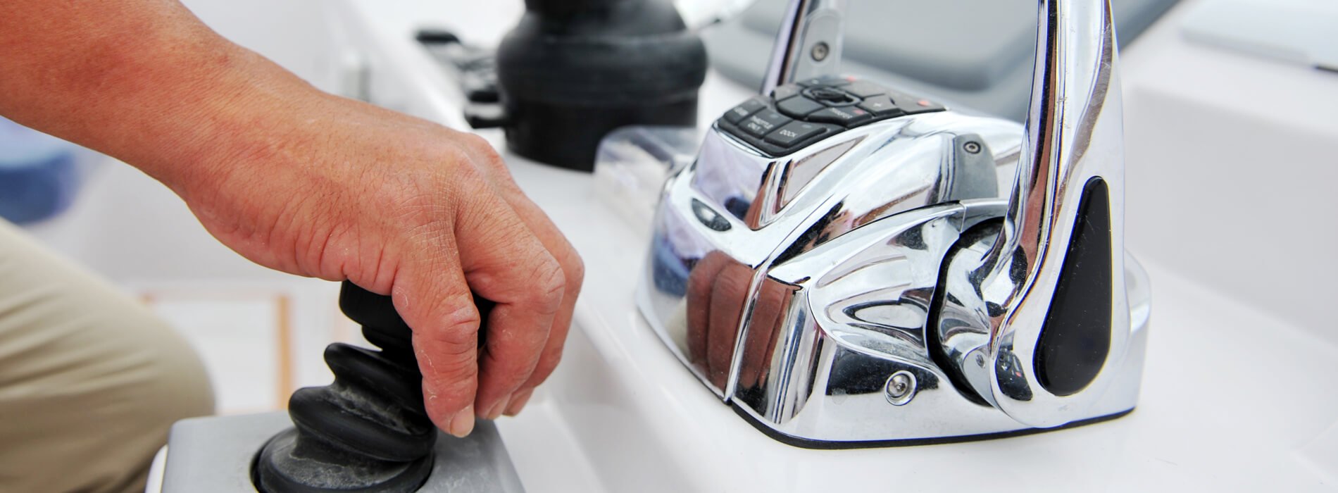 Close up on man's hand controlling yacht.