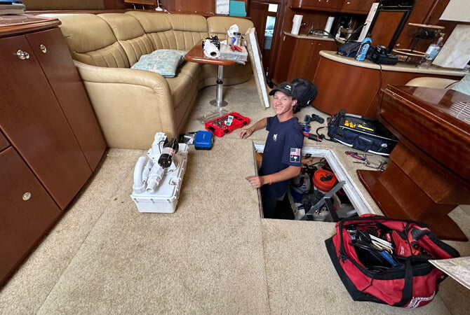 Technician working under floor of yacht.